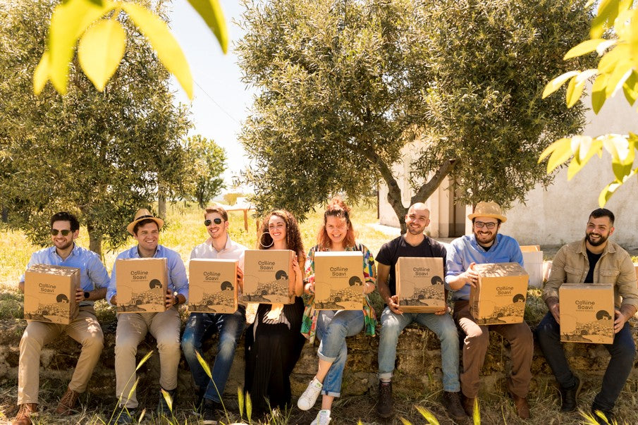 un gruppo di ragazzi in posa con una confezione di olio extravergine di oliva Colline Soavi