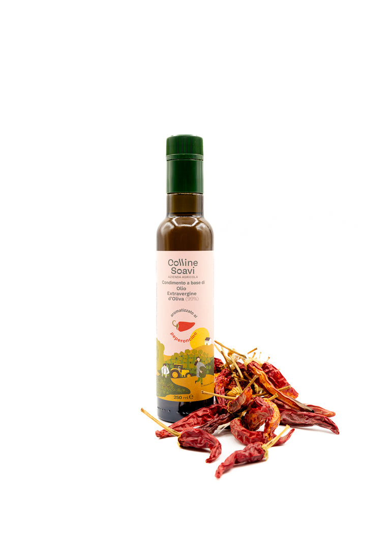 Bottiglia di Olio Aromatizzato Colline Soavi al gusto Peperoncino con accanto dei peperoncini secchi